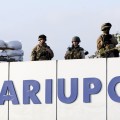 Ukrainian soldiers stand guard at the airport as military personnel and staff meet Ukrainian President Petro Poroshenko in the southern coastal tow