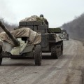 Members of the Ukrainian armed forces ride armoured personnel carriers as they pull back from Debaltseve region, near Artemivsk