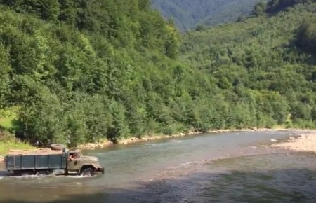 Навантажений лісовоз переїжджає гірську річку, відео