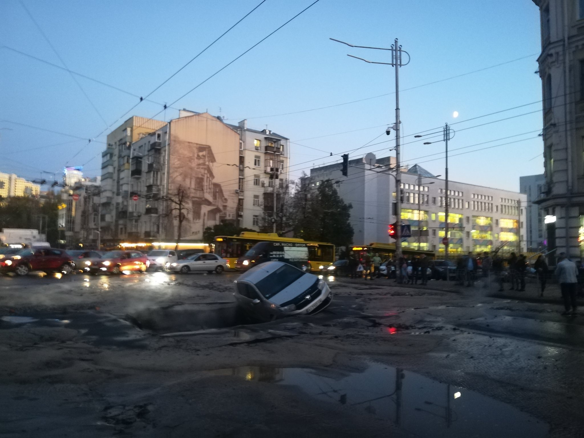 Прорив труби з гарячою водою: у центрі Києва автівка провалилася в яму на дорозі (відео)