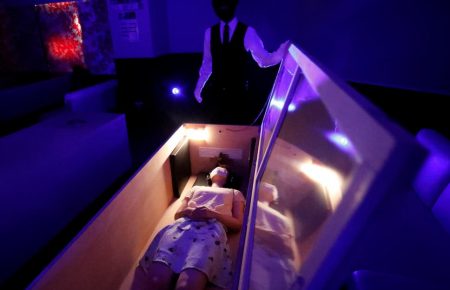 Снять стресс от коронавируса: в Токио уличный театр предлагает полежать в гробу в окружении зомби (видео)