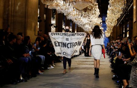 Активістка вийшла на подуім під час показу Louis Vuitton із плакатом: «Надмірне споживання = вимирання», її відтягла охорона (ВІДЕО)